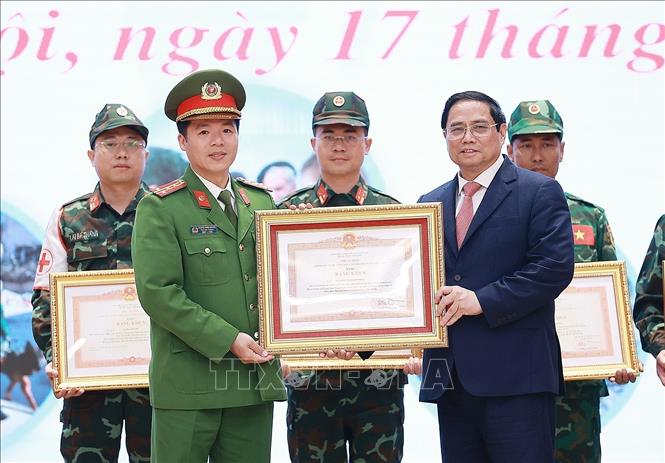 PM Pham Minh Chinh presents the certificates of merit to collectives and individuals in recognition of their contributions to the effort. VNA Photo: Dương Giang
