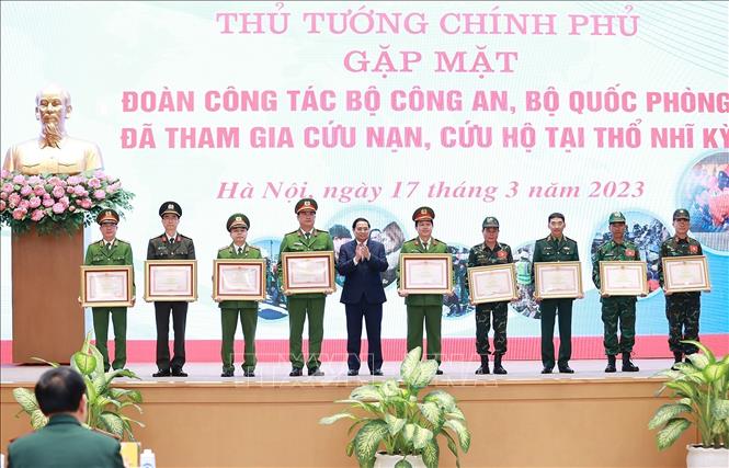 PM Pham Minh Chinh presents the certificates of merit to collectives and individuals in recognition of their contributions to the effort. VNA Photo: Dương Giang