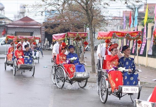 Hạnh phúc của các cặp đôi cô dâu chú rể đến hôn trường bằng xe xích lô trong lễ cưới tập thể theo nếp sống văn minh tại Hà Nội. Ảnh: Dương Giang –TTXVN