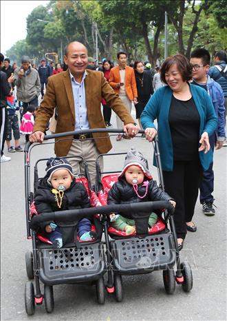 Hình ảnh ông bà mẫu mực, gia đình hạnh phúc (ảnh chụp tại phố đi bộ hồ Hoàn Kiếm). Ảnh: Thành Đạt - TTXVN