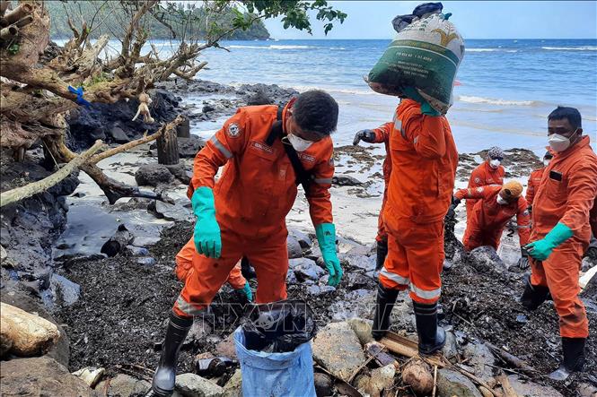 Lực lượng bảo vệ bờ biển và các tình nguyện viên dọn dầu tràn trên bãi biển ở Pola, tỉnh Oriental Mindoro, Philippines, ngày 8/3/2023. Ảnh: AFP/ TTXVN