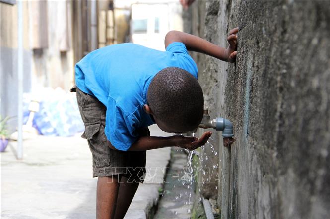 (Tư liệu) Trẻ em uống nước tại vòi nước công cộng ở Lagos, Nigeria. Ảnh: AFP/ TTXVN