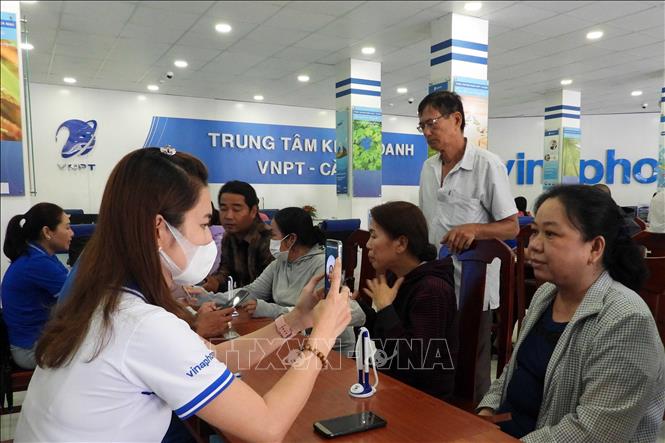 Nhân viên VNPT Cà Mau hỗ trợ người dân chuẩn hóa thông tin thuê bao di động. Ảnh: Kim Há-TTXVN