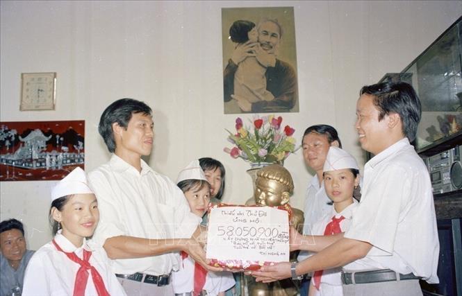 Đại diện Hội đồng Đội Hà Nội trao hiện vật và tiền quyên góp của thiếu nhi Thủ đô ủng hộ phong trào 