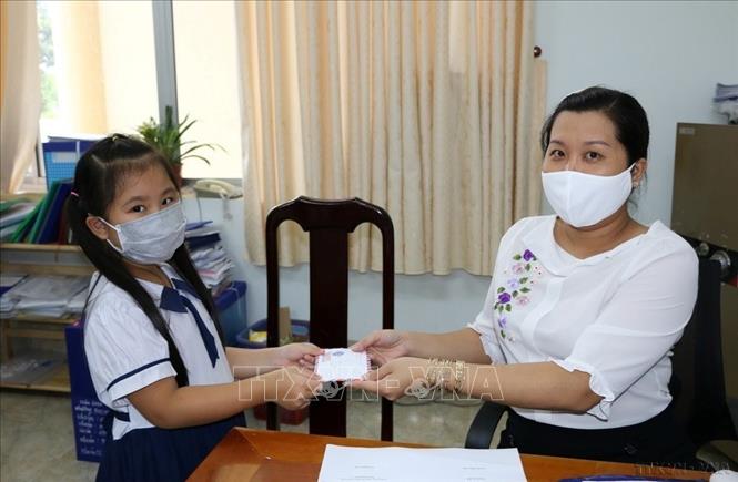 Từ tiền tiết kiệm heo đất, em Nguyễn Quốc Minh Khuê, học sinh lớp 1/1 Trường Tiểu học Chu Văn An, thành phố Cao Lãnh, đến Ủy ban MTTQ Việt Nam tỉnh Đồng Tháp để đóng góp vào Quỹ vaccine phòng, chống dịch COVID-19. Ảnh: Chương Đài - TTXVN
