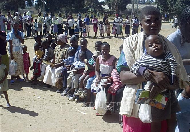 (Tư liệu) Các bà mẹ đưa con nhỏ đi tiêm phòng sởi tại khu dân cư ở Harare, Zimbabwe. Ảnh: AFP/ TTXVN