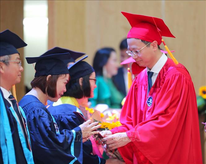 PGS.TS Nguyễn Văn Hiền, Phó Hiệu trưởng Trường đại học Sư phạm Hà Nội trao bằng cho các tân Thạc sĩ trong buổi lễ. Ảnh: Thanh Tùng - TTXVN