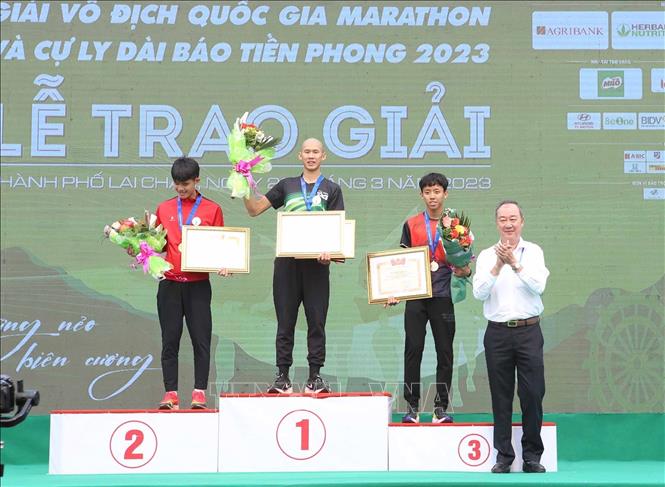 Ban tổ chức trao giải Nhất, Nhì và Ba cho các vận động viên tuyển nam chuyên nghiệp ở cự ly 21 km. Ảnh: Quý Trung – TTXVN