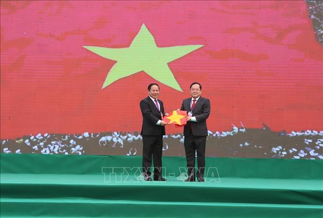Tổng Biên tập Báo Tiền phong Lê Xuân Sơn trao lá cờ tổ quốc cho Phó Chủ tịch UBND tỉnh Lai Châu Tống Thanh Hải. Ảnh: Quý Trung – TTXVN