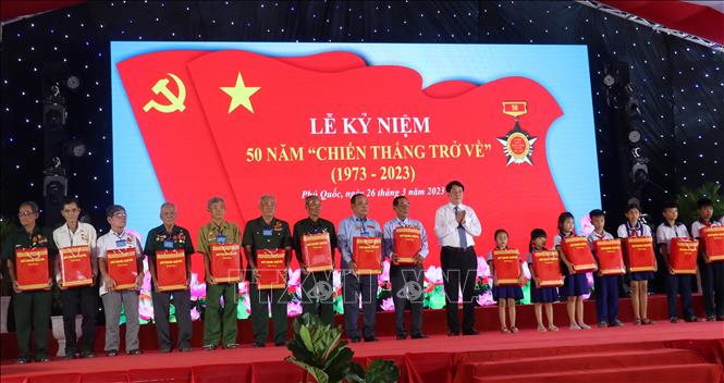 Trong ảnh: Đại tướng Lương Cường, Ủy viên Bộ Chính trị, Chủ nhiệm Tổng Cục Chính trị Quân đội nhân dân Việt Nam tặng quà cho các cựu tù Trại giam Tù binh Cộng sản Việt Nam - Phú Quốc và học sinh trên đảo ngọc. Ảnh: Lê Huy Hải - TTXVN