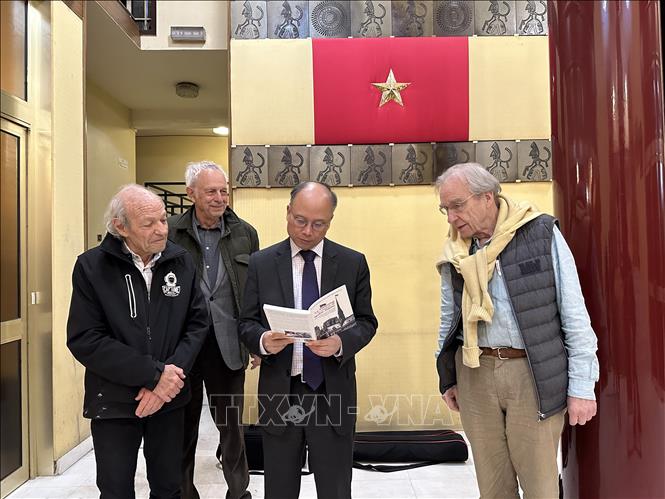 Ba công dân Thụy Sĩ, Bernard Bachelard (thứ nhất bên trái), Noé Graff (thứ hai bên trái), và Olivier Parriaux (thứ nhất bên phải), trao tặng Đại sứ Việt Nam tại Pháp cuốn sách của họ. Ảnh: Thu Hà - PV TTXVN tại Pháp