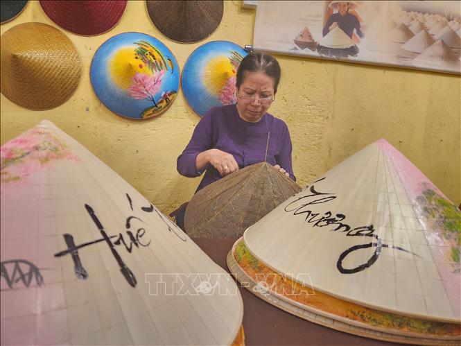 Performance of making a conical hat, a traditional craft at the street. VNA Photo: Mai Trang