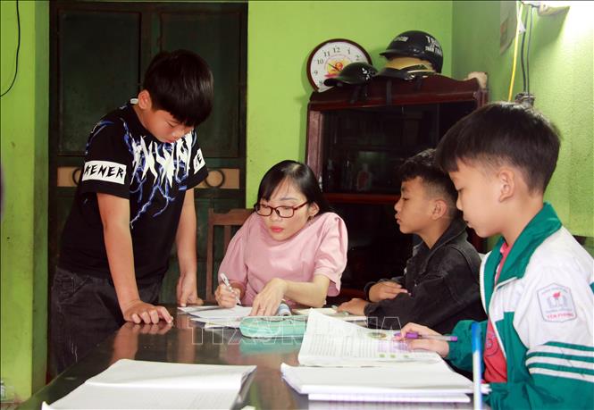 Trong ảnh: Cô giáo Ngọc Tâm thủy tinh hướng dẫn học sinh làm bài tập tại lớp học “5 không”. Ảnh: Văn Đạt - TTXVN