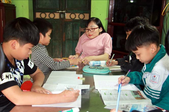 Trong ảnh: Cô giáo Ngọc Tâm thủy tinh hướng dẫn học sinh làm bài tập tại lớp học “5 không”. Ảnh: Văn Đạt - TTXVN
