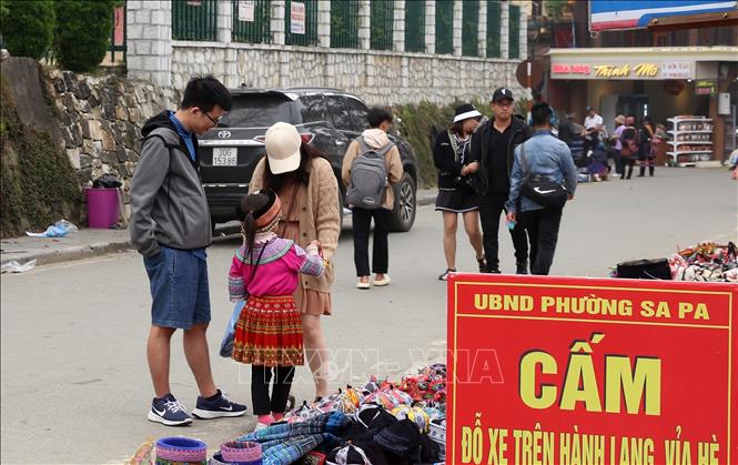 Trong ảnh: Những trẻ em mặc trang phục là người đồng bào dân tộc tiếp cận du khách để chèo kéo mua hàng. Ảnh: Quốc Khánh - TTXVN