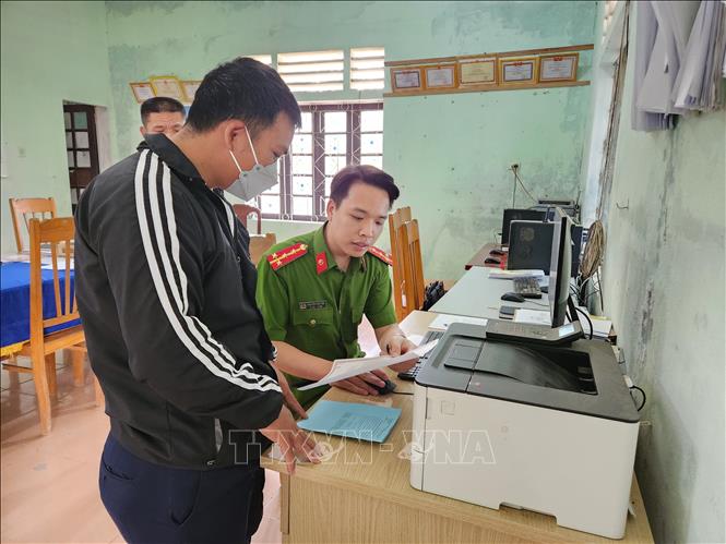 Đại uý Tân tận tình chỉ dẫn thủ tục cho người dân xã Quảng Nhâm. Ảnh: Mai Trang-TTXVN