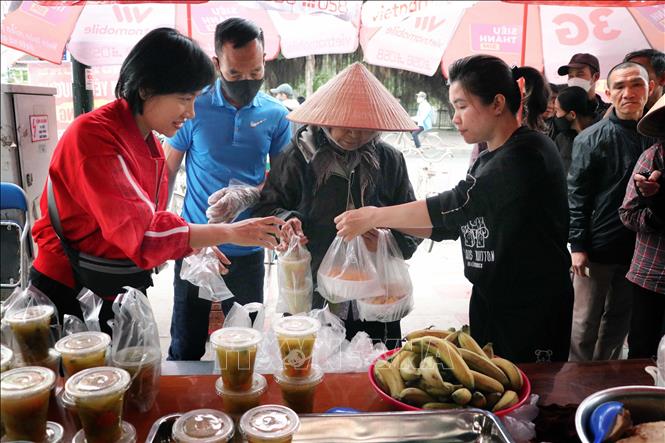 Trong ảnh: Anh chị em tổ cơm từ thiện bán các suất cơm từ thiện tới người có hoàn cảnh khó khăn. Ảnh: Hoàng Ngọc-TTXVN