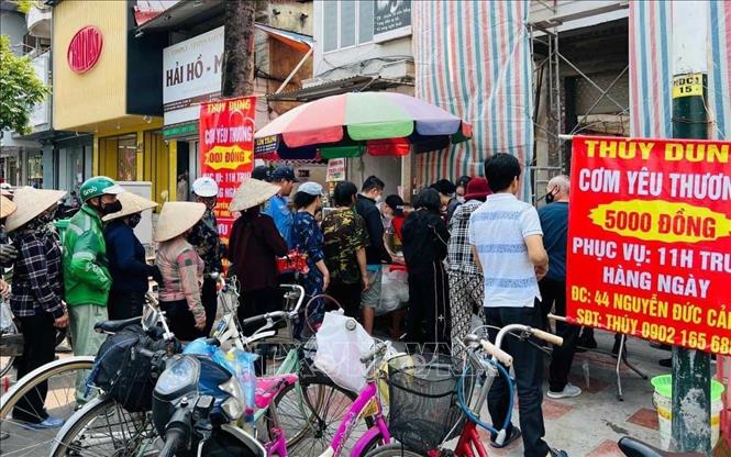 Trong ảnh: Những suất cơm trưa từ thiện dành người có hoàn cảnh khó khăn. Ảnh: Hoàng Ngọc-TTXVN