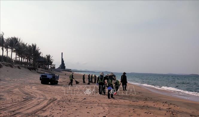 Lực lượng chức năng thành phố Tuy Hoà với gần 100 người tham gia thu gom dầu vón cục dọc bờ biển vào chiều 31/3. Ảnh: TTXVN phát