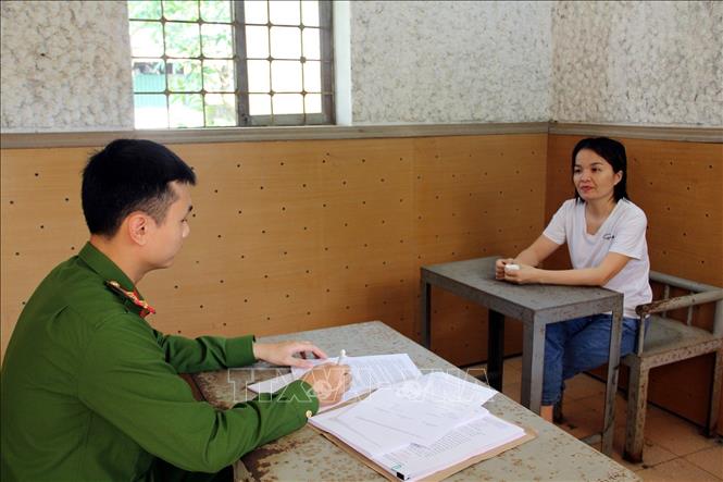 Trong ảnh: Đối tượng Phan Thị Hòa làm việc với cơ quan công an. Ảnh: TTXVN phát