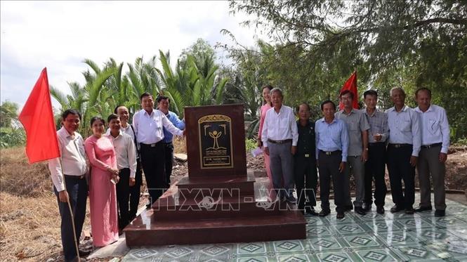 Bia tưởng niệm cạnh cây me, ghi dấu trận thảm sát trong chiến tranh với hàng ngàn thanh thiếu niên và người dân đã hy sinh tại ấp 6, xã Tân Bửu. Ảnh: TTXVN phát