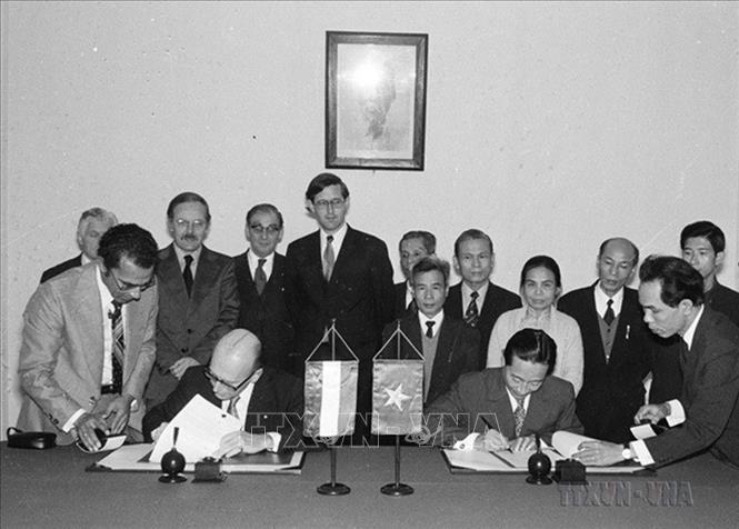 Thứ trưởng Bộ Ngoại giao Phan Hiển và ông John Mann, Tổng vụ phó Vụ Hợp tác Kinh tế Bộ Ngoại giao Hà Lan thay mặt 2 chính phủ ký văn kiện hợp tác kinh tế Việt Nam – Hà Lan (Hà Nội, 15/12/1976). Ảnh: Thế Trung – TTXVN