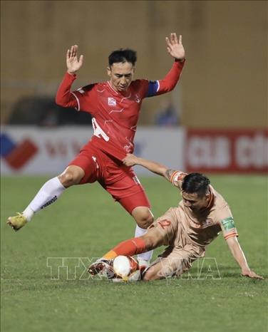 Tình huống phạm lỗi của cầu thủ Hải Huy (số 14, Hải Phòng) với cầu thủ Trần Văn Trung (số 22, CAHN). Ảnh: Minh Quyết - TTXVN