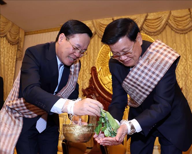 President Vo Van Thuong and Party General Secretary and President of Laos Thongloun Sisoulith attend a wrist threading ceremony on the occasion of Lao traditional New Year Bunpimay in Vientiane on April 10. VNA Photo: Thống Nhất