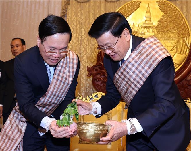 President Vo Van Thuong and Party General Secretary and President of Laos Thongloun Sisoulith attend a wrist threading ceremony on the occasion of Lao traditional New Year Bunpimay in Vientiane on April 10. VNA Photo: Thống Nhất