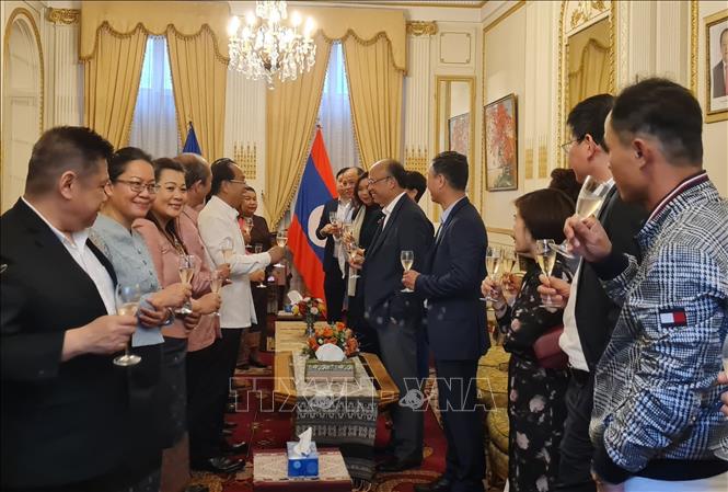 Trong ảnh: Cán bộ nhân viên Đại sứ quán Lào và Việt Nam nâng cốc chúc mừng nhân dịp Tết cổ truyền Bun Pi May. Ảnh: TTXVN phát
