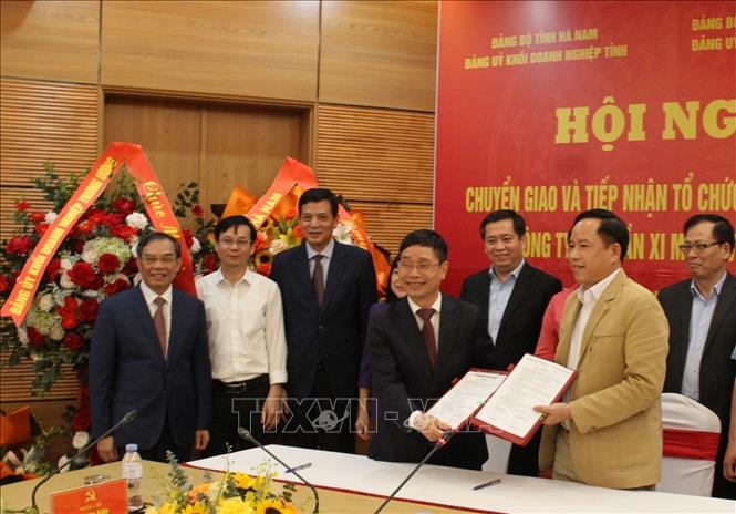 Đại diện 2 bên thực hiện nghi thức chuyển giao. Ảnh: Thanh Tuấn - TTXVN 