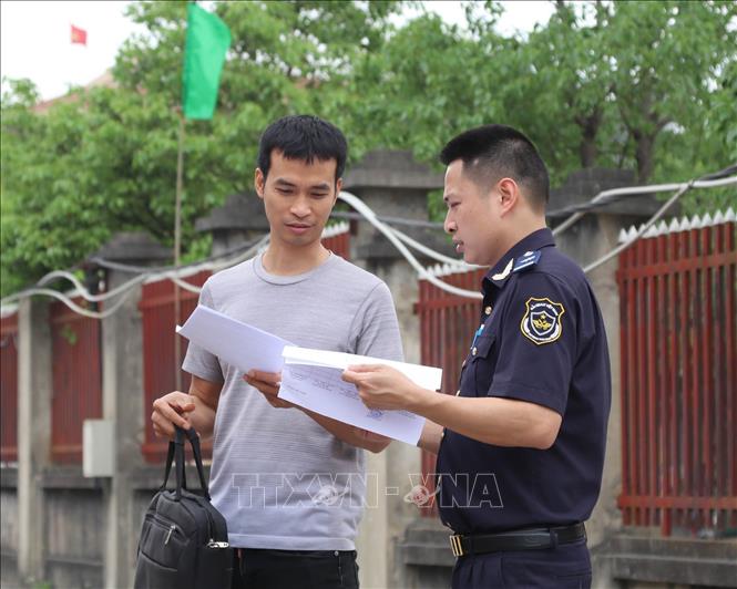 Công chức Chi cục Hải quan cửa khẩu Chi Ma tra soát giấy tờ hàng hóa tại bãi sang tải hàng cửa khẩu. Ảnh: Quang Duy - TTXVN