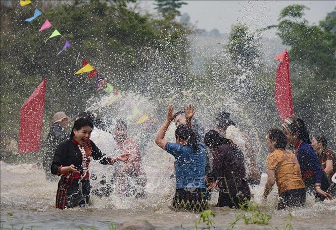 Locals and tourists join in the water splashing rituals on the village's spring. VNA Photo: Xuân Tư 