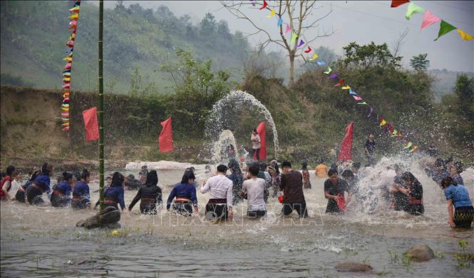 Locals and tourists join in the water splashing rituals on the village's spring. VNA Photo: Xuân Tư