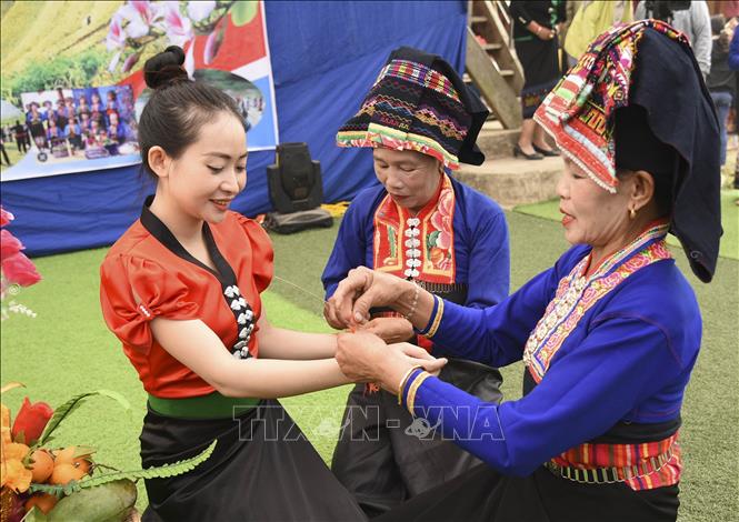 Wrist thread typing ritual is included in the festival. VNA Photo: Xuân Tư