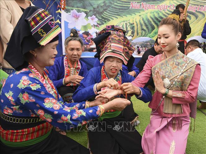 Wrist thread typing ritual is included in the festival. VNA Photo: Xuân Tư