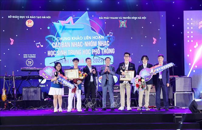 Ban tổ chức trao giải Nhì cho ban nhạc Kimlienmusic club (THPT Kim Liên) và Medley Melody THPT Phan Huy Chú - Đống Đa). Ảnh: Thanh Tùng - TTXVN 