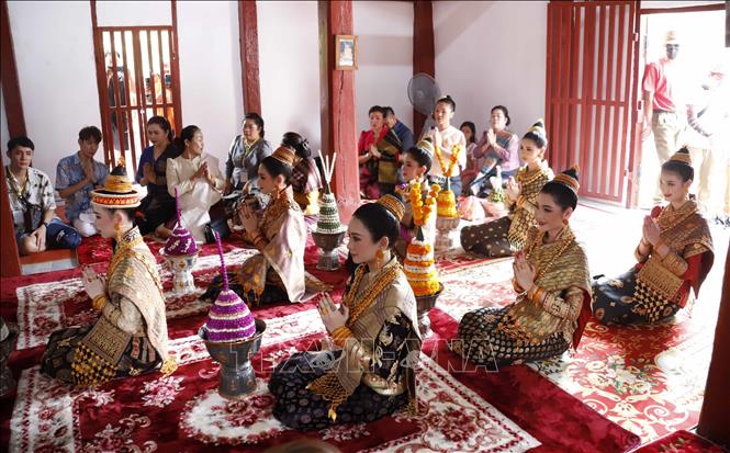 Bảy người con gái của thần Kabinlaphom trong đó có Nang Sangkhane Luang Prabang 2023 đang thực hiện các nghi lễ tôn giáo trước khi lễ rước Nang Sangkhane Luang Prabang 2023 bắt đầu. Ảnh: Phạm Kiên - Phóng viên TTXVN tại Lào.