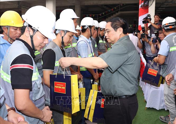 Thủ tướng Phạm Minh Chính tặng quà công nhân thi công dự án xây dựng mới Bệnh viện Đa khoa khu vực Thủ Đức. Ảnh: Dương Giang-TTXVN
