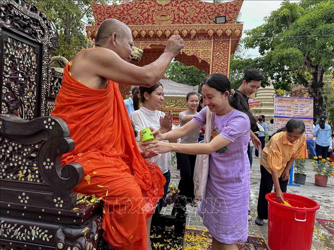 Phật tử thực hiện nghi thức tắm hoặc rửa tay, chân cho sư trụ trì sau khi tắm tượng Phật. Ảnh: Thanh Liêm - TTXVN