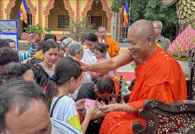 Sư trụ trì xoa đầu các cháu thiếu nhi trong Lễ tắm Phật với ý nghĩa chúc phúc trong năm mới. Ảnh: Thanh Liêm - TTXVN