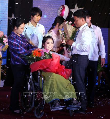 Thí sinh Nguyễn Thị Ánh Ngọc đoạt giải nhất Liên hoan “Vẻ đẹp vầng trăng khuyết 2013” (tên gọi cũ là Cuộc thi Hoa hậu người khuyết tật) nhằm tôn vinh nét đẹp của nữ thanh niên khuyết tật. Ảnh: Phạm Kiên – TTXVN