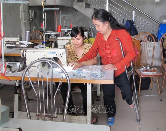 Bà Nguyễn Thị Hòa, chủ xưởng may gia công tại khu phố 5, thị trấn Yên Ninh, huyện Yên Khánh (Ninh Bình) là một người khuyết tật. Hàng chục năm hoạt động, xưởng may của bà đã đào tạo cho hàng nghìn công nhân may, trong đó có khoảng 500 người khuyết tật. Ảnh: Ninh Đức Phương - TTXVN