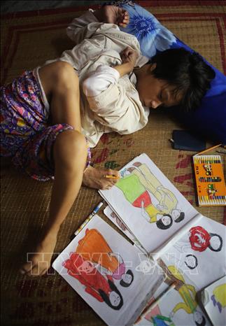 Mặc dù bị tật nguyền, chân tay co quắp, nhưng với ý chí và nghị lực, chị Huỳnh Thị Thảnh, ở thôn Hải Tân, xã Hương Bình, thị xã Hương Trà (Thừa Thiên-Huế) đã dùng đôi chân vẽ nên những bức tranh đẹp. Ảnh: Hồ Cầu-TTXVN 