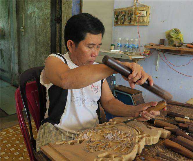 Hội viên Lê Viết Luận (Hội Người khuyết tật huyện Diên Khánh, tỉnh Khánh Hòa) là người thầy truyền nghề chạm khắc cho các hội viên khuyết tật khác. Ảnh: Phan Sáu - TTXVN