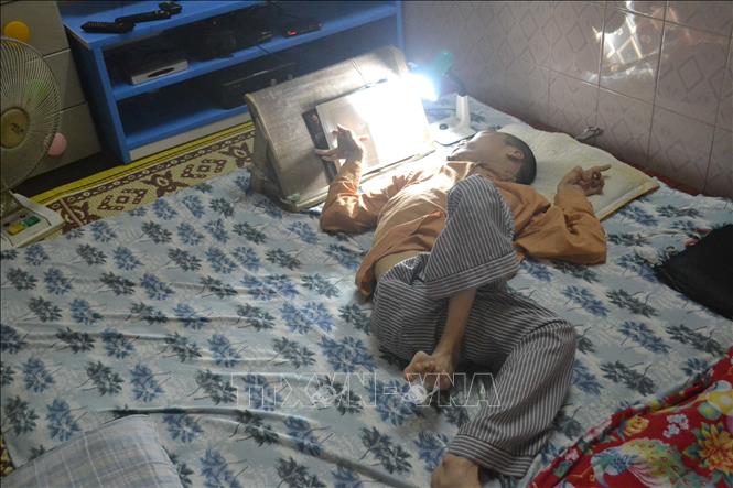 Là nạn nhân của di chứng chất độc da cam/dioxin, hơn 30 năm nay anh Đỗ Hà Cừ (tổ 35, phường Trần Lãm, TP. Thái Bình) không thể đi lại, chân tay co quắp và nằm một chỗ. Vượt lên số phận, năm 2015, anh và gia đình đã kêu gọi, tìm sự giúp đỡ để xây dựng không gian đọc đặc biệt có tên “Hy vọng”, thắp lên tình yêu với những cuốn sách. Ảnh: Thu Hoài-TTXVN