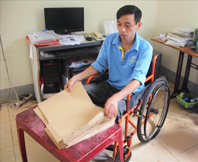 Anh  Nguyễn Văn Công, sinh năm 1976, quê xã Kỳ Tân, thị xã Kỳ Anh (Hà Tĩnh) bị liệt cả 2 chân sau một cơn sốt kéo dài, khiến việc đi lại anh đều phải nhờ vào chiếc xe lăn. Không khuất phục trước số phận, Công luôn tỏ ra lạc quan, yêu đời, vượt qua mọi khó khăn trong cuộc sống, trở thành người có ích cho xã hội. Hiện anh là nhân viên có tay nghề ở xưởng in lưới của Trung tâm dạy nghề, giới thiệu và giải quyết việc làm cho người tàn tật Hà Tĩnh. Ảnh: Phan Quân - TTXVN