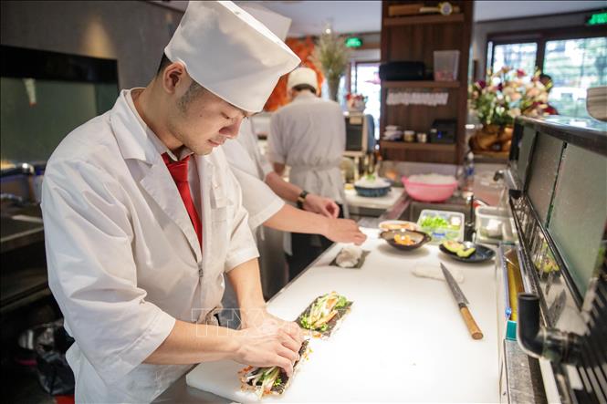 Đầu bếp nhà hàng New Sushi (phố Đào Tấn) chuẩn bị thực đơn cơm cuộn theo phong cách truyền thống Nhật Bản. Ảnh: Hoàng Hiếu - TTXVN