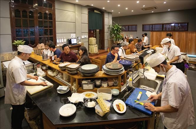 Đến quán Takumi (quán ăn Nhật Bản trên phố Linh Lang), thực khách ngoài được thưởng thức ẩm thực, các món ăn tươi, ngon, còn được tìm hiểu về văn hóa, giao lưu với những người Nhật Bản đang sinh sống, làm việc tại Hà Nội. Ảnh: Hoàng Hiếu - TTXVN  