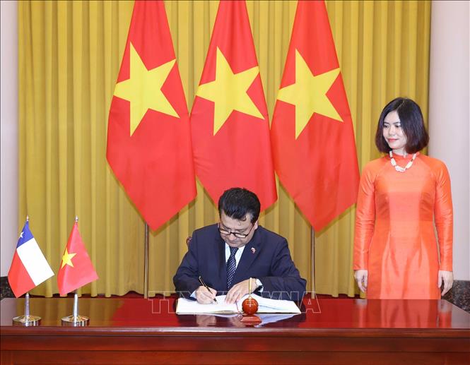 Đại sứ Chile Sergio Narea Guzmán viết lưu bút vào Sổ vàng lưu niệm. Ảnh: Thống Nhất – TTXVN